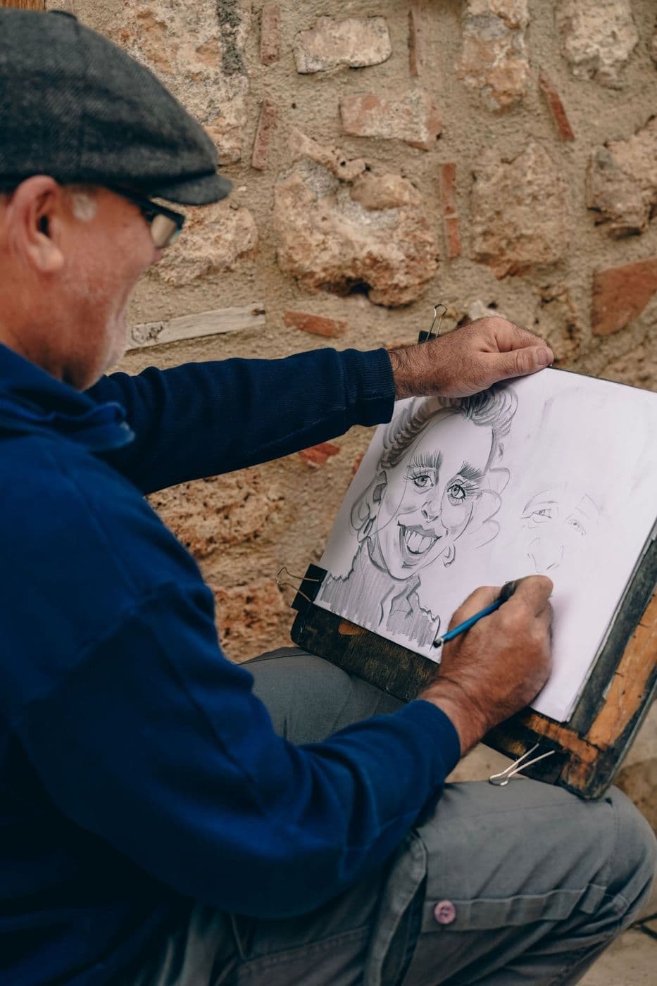 Caricaturist sketching a pencil portrait on his easel
