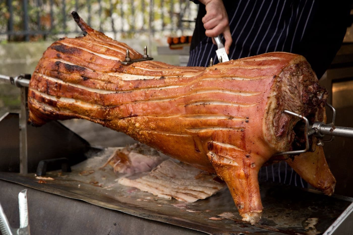 Cochon rôti à la broche découpé par un cuisinier