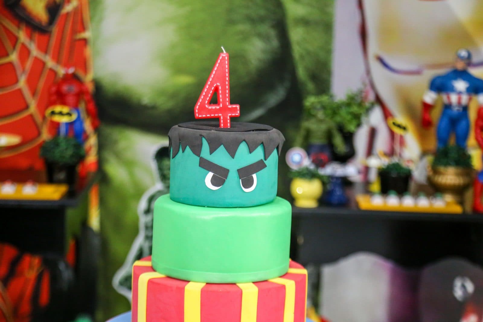 Superhero birthday cake with a number 4 candle