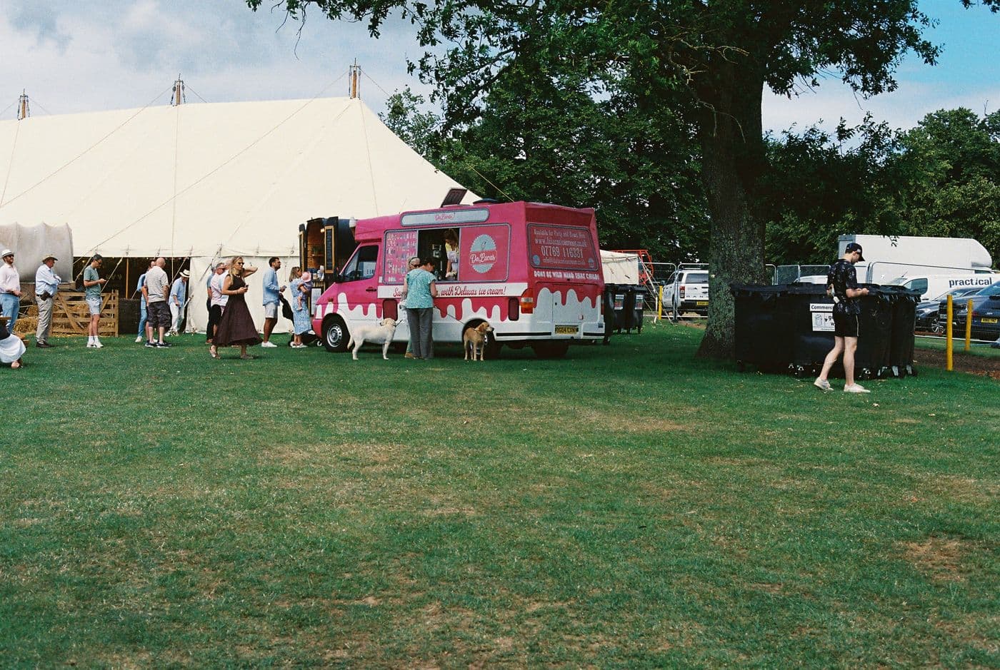 Pink ice cream van in front of a large marquee at a country reception