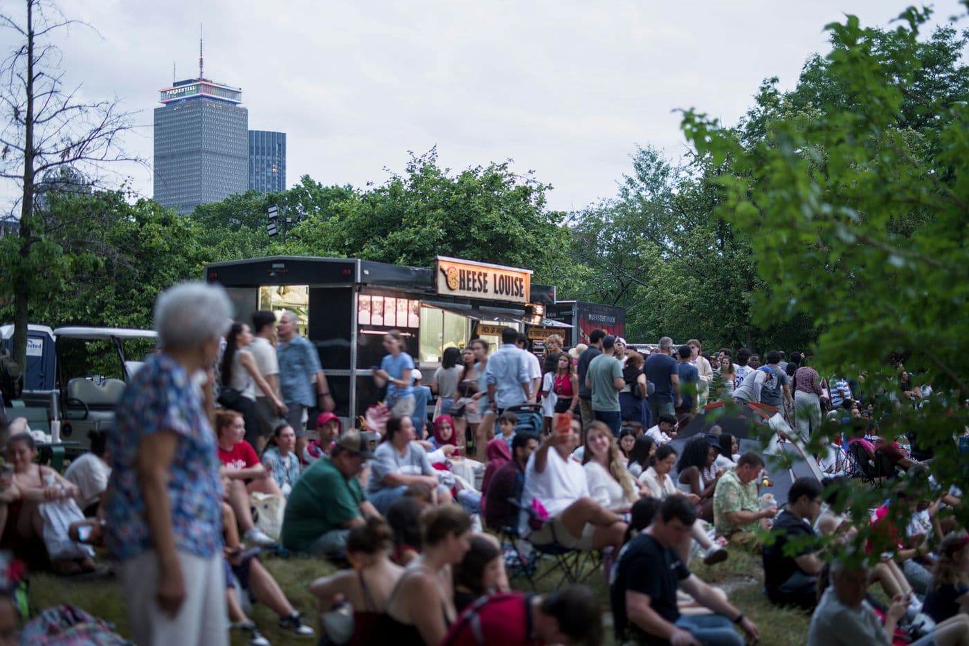 Food trucks dans un parc, entourés d'invités assis dans l'herbe