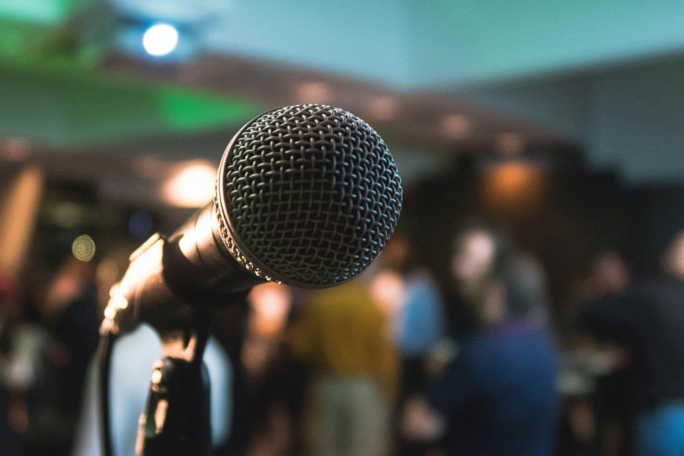 Close-up of a microphone in front of guests at a party