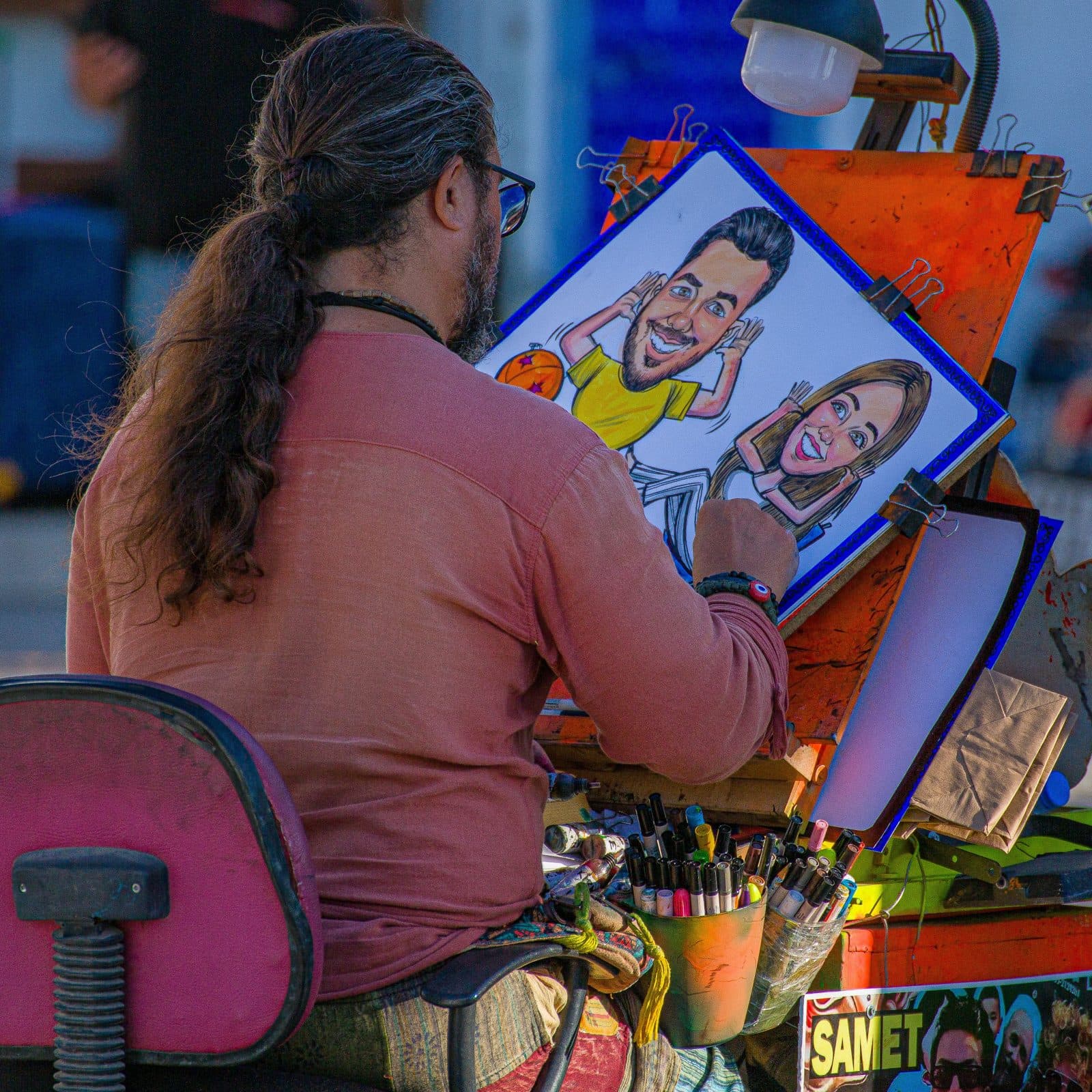 Artiste dessinant le portrait d'un couple sur son chevalet