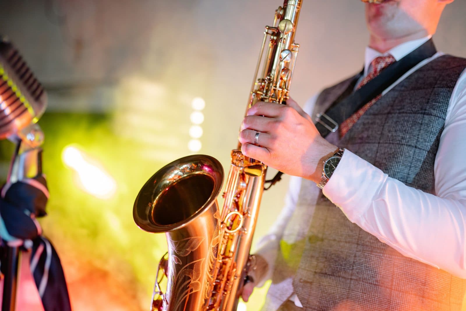 Saxophoniste en gilet devant un micro vintage