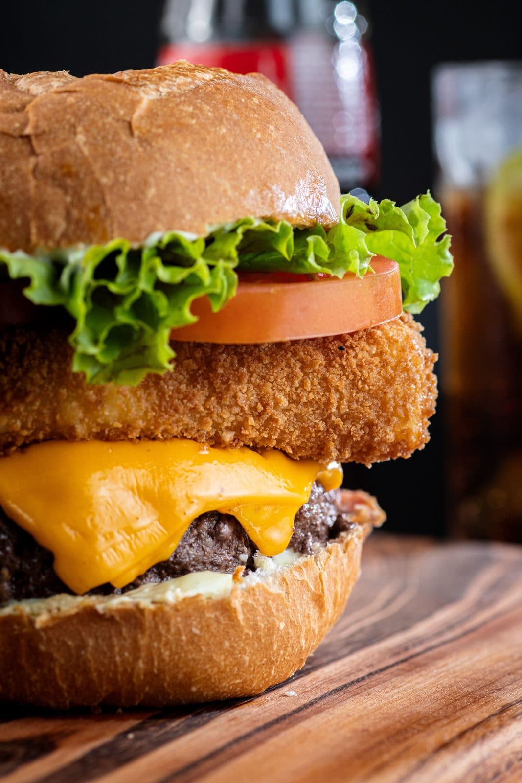 Burger garni de cheddar, poulet pané, tomate et salade