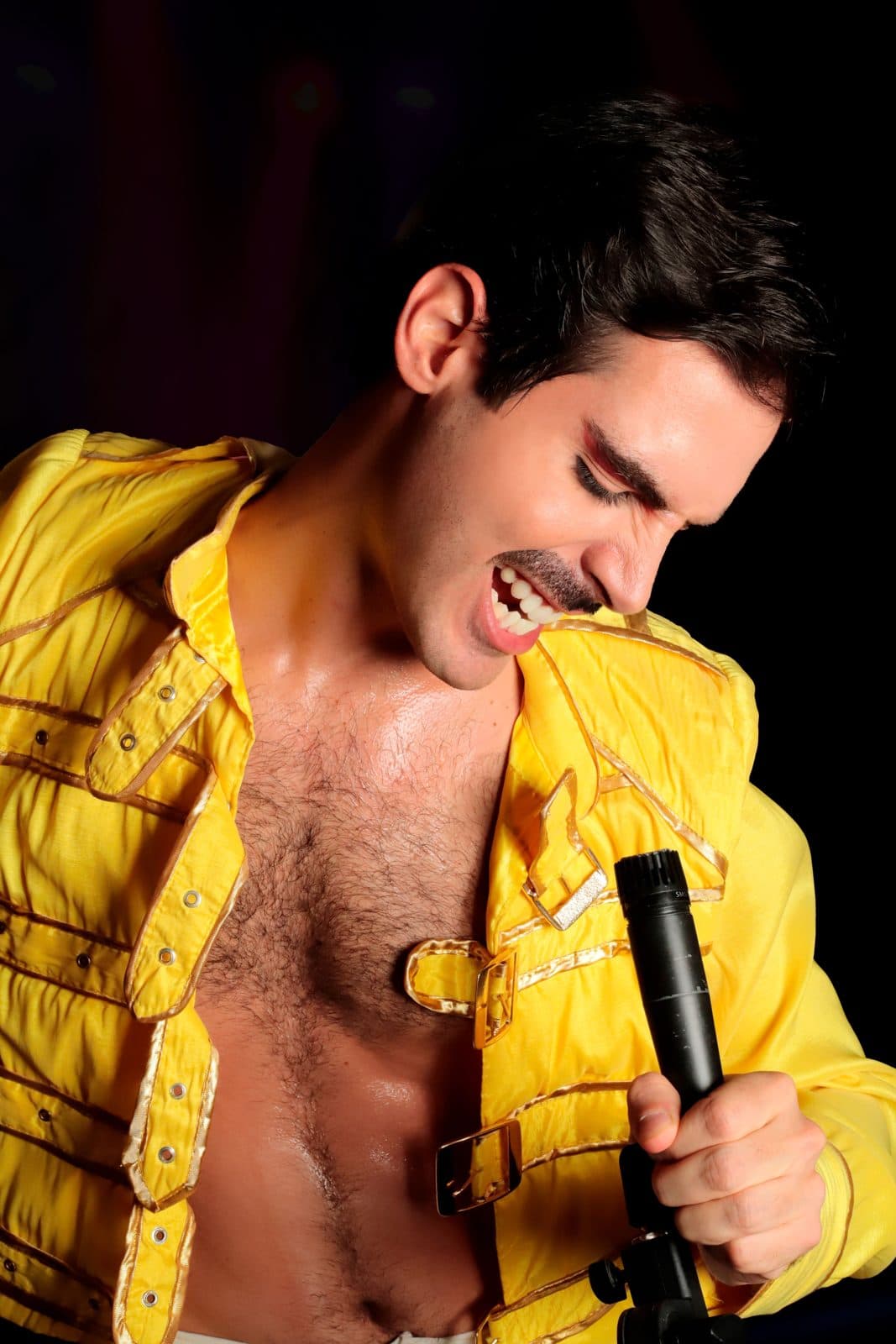 Chanteur en veste jaune lors d'un spectacle hommage